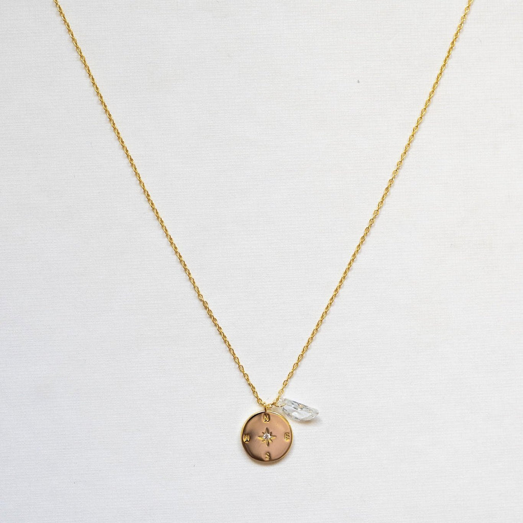 This exquisite necklace features a stunning sterling silver compass adorned with a clear quartz moon shape, symbolizing clarity, direction, and illumination. - gold plated