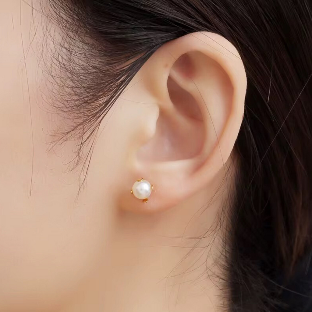 White pearl stud earrings with gold prong